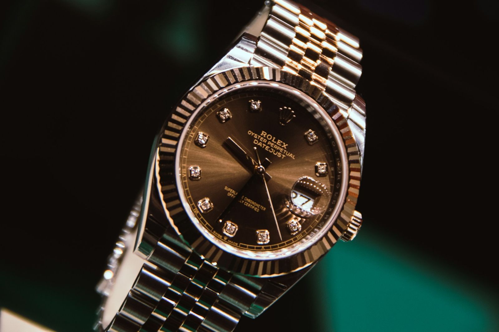 A silver and gold analog watch set to 10:10, the kind of possession that quietly asks to be maintained, insured, and worried about